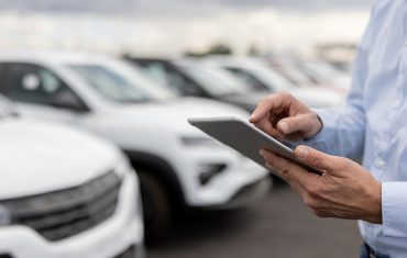 Close-up-on-a-car-salesperson-using-a-tablet-computer-at-the-car-dealership