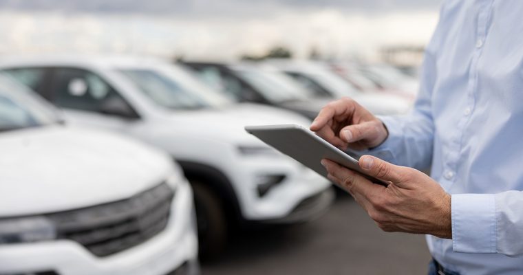 Close-up-on-a-car-salesperson-using-a-tablet-computer-at-the-car-dealership