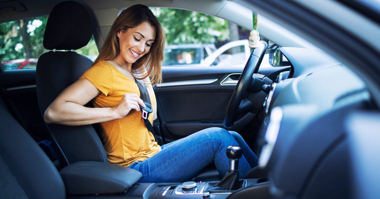 Woman putting on seatbelt 