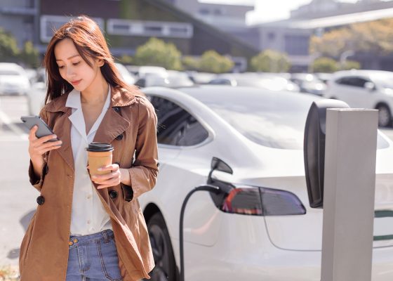 Woman charging electric vehicle