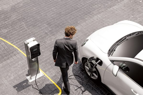 Man charging electric vehicle